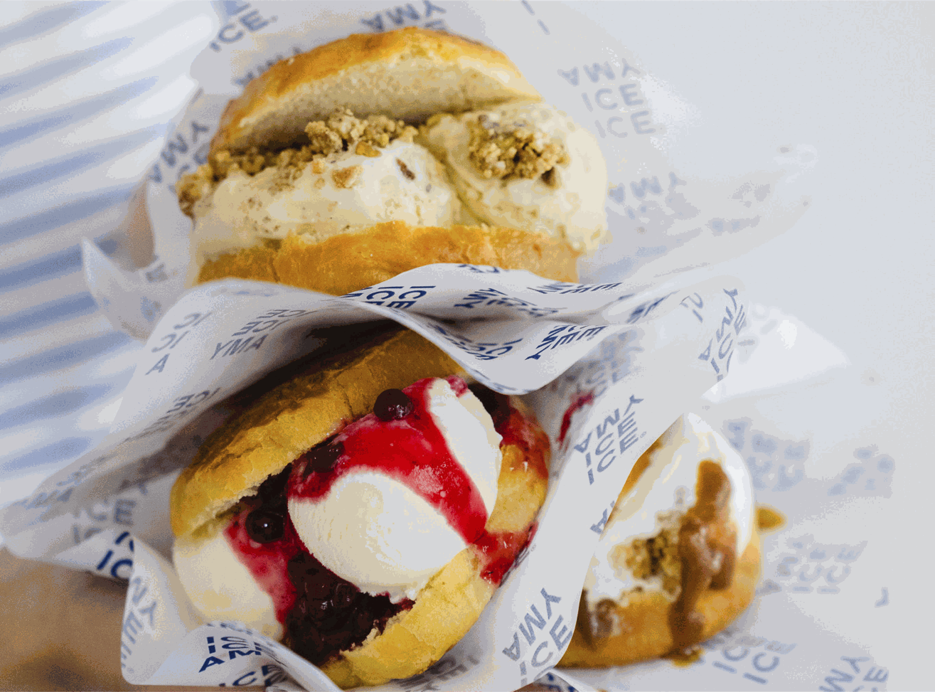 Twee briochebroodjes gevuld met ijs, bessencompote en crumble, verpakt in Ice Ice Amy-papier.